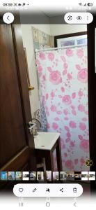a bathroom with a pink flowered shower curtain and a sink at S de uribe 2 in Uribelarrea