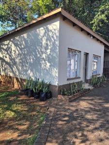 a white house with plants in front of it at Melvillas in Louis Trichardt