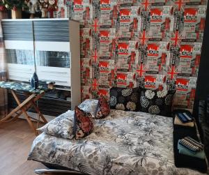 a living room with a couch in front of a wall at Tosmare Apartament in Liepāja