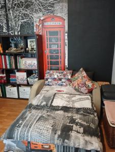 a bed with a red telephone box in a room at Tosmare Apartament in Liepāja +19 photos