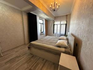 a bedroom with a bed and a chandelier at Caspian Boulevard Residence in Sumqayıt +30 photos