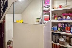a small refrigerator in a kitchen with its door open at RedDoorz at Jatisampurna  +16 photos