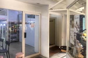 a room with glass doors and a table and chairs at RedDoorz at Jatisampurna 