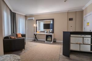 a living room with a couch and a television at Siete Hotel in Antalya