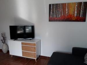 Apartamento Club Valena في بويرتو ديل كارمن: غرفة معيشة مع تلفزيون بشاشة مسطحة على خزانة