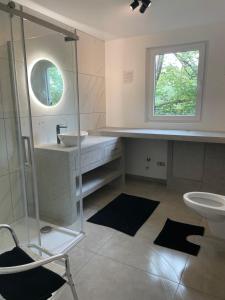 a bathroom with a shower and a sink and a chair at Bandrew in Stoumont +15 photos