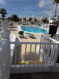 a white railing next to a swimming pool at Apartamento Club Valena in Puerto del Carmen