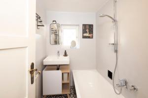 a white bathroom with a sink and a shower at Familienparadies - Chalet Hoamatl in Achenkirch