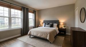 a bedroom with a large bed and two windows at Bertinas stay in Diepholz