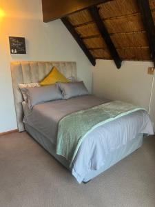 a bedroom with a large bed with a wooden ceiling at Serendipity Guest House in Richards Bay