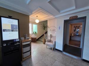 a lobby with a waiting room with a chair and a window at 고요스테이 in Chuncheon