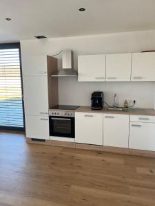 a kitchen with white cabinets and a stove top oven at Apartment Naturblick in Strem