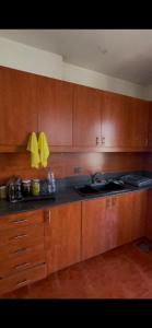 a kitchen with wooden cabinets and a sink and a stove at Haidar house in Baabda