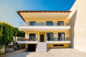 a house with a balcony and stairs in front of it at Vero Mare in Pefkochori