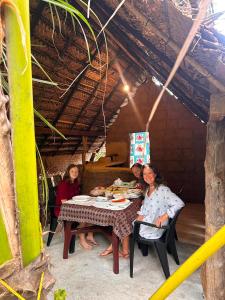 three women sitting at a table eating food at Sigiriya Carpenter Cottage in Sigiriya +28 photos