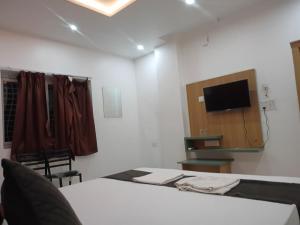 a room with a bed and a tv on a wall at Hotel Rudra Heritage in Jasidih