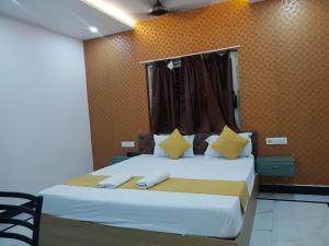 a bedroom with a large bed with yellow walls at Hotel Rudra Heritage in Jasidih +6 photos
