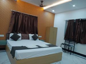 a bedroom with a large bed and a chair at Hotel Rudra Heritage in Jasidih