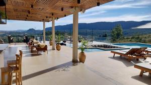 un patio con tavolo e sedie e una piscina di Serrano Exclusive a Tiradentes