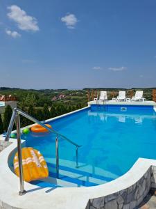 a large blue swimming pool with chairs on top at Kuća Pored Sunca in Kruševac