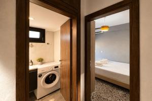 a bathroom with a washing machine next to a bed at Vero Mare in Pefkochori