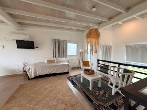 a bedroom with a bed and a chair and a television at Casa Calamar en Casa Pampa in Chapadmalal +41 photos