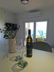 a bottle of wine sitting on a table with a glass at Apartman NoTi in Milna