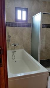 a bath tub in a bathroom with a window at Le Ranch Hôtel San-Pedro in San-Pédro