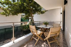 a balcony with a table and chairs and a tree at Vero Mare in Pefkochori