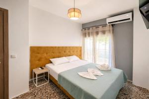 a bedroom with a bed with two hats on it at Vero Mare in Pefkochori