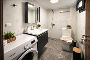 a bathroom with a sink and a washing machine at Vero Mare in Pefkochori +39 photos