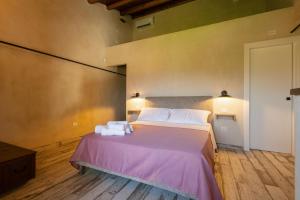 a bedroom with a pink bed with towels on it at Mulino 1220 in Scopello