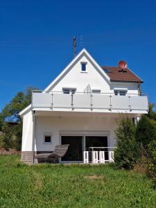a white house on top of a grassy hill at WineArtB&B in Oberreichenbach