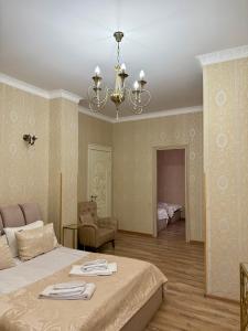a bedroom with two beds and a chandelier at Borjomi Classic Hotel in Borjomi