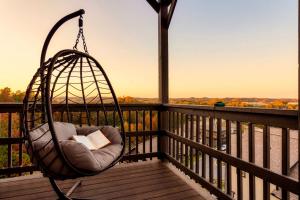 a swing on a porch with a book at Open Skydeck with Spectacular View and Hot Tub in Sevierville