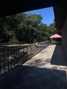 a walkway with a fence and a red umbrella at Queens Safehouse in Brozany