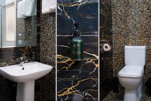 a black and gold bathroom with a toilet and a sink at N'Log N'Skuraj Hotel in Ferr -Skuraj