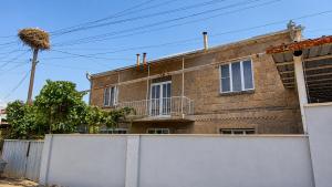 a brick house with a white fence in front of it at PIT STOP B&B Guesthouse in Urtsʼadzor