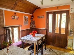 a dining room with orange walls and a table at Smestaj Bojanine Vode in Niš +20 photos