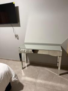 a silver desk with a television on a wall at Highveld Nook in Sasolburg