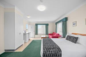 a bedroom with a bed and a living room at Maynestay Motel in Gunnedah