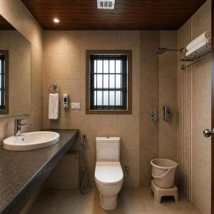 a bathroom with a toilet and a sink at Aachman Regency Shimla Mallroad in Jutogh