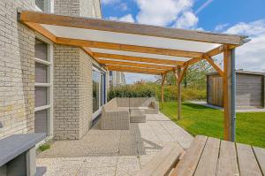 a wooden pergola on the side of a building at Villa Mooy met sauna - Landal park Ooghduyne Julianadorp aan Zee in Julianadorp