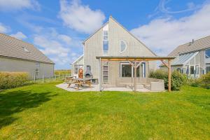 a house with a picnic table in the yard at Villa Mooy met sauna - Landal park Ooghduyne Julianadorp aan Zee in Julianadorp