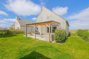 a house with an open patio in the yard at Villa Mooy met sauna - Landal park Ooghduyne Julianadorp aan Zee in Julianadorp +79 photos