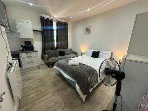 a bedroom with a bed and a fan in it at Wimbledon Family Studio Flat 1 in London