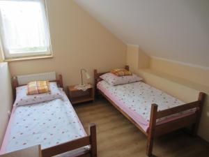 two twin beds in a room with a window at Ostoja w Lipowcu in Jaśliska