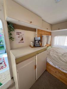 a kitchen in a small room with a bed at Przyczepa Kempingowa Beige in Jastarnia