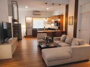 a living room with two couches and a kitchen at Zen Ocean Villa -Sri Thanu in Ko Phangan