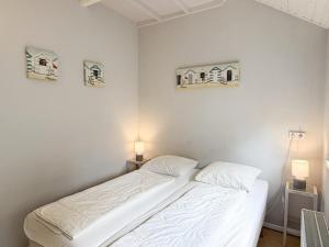 a bed in a bedroom with two pictures on the wall at Texelheerlijk 1 in De Koog